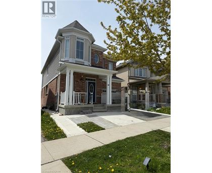 A house with a porch and a tree in front of it.