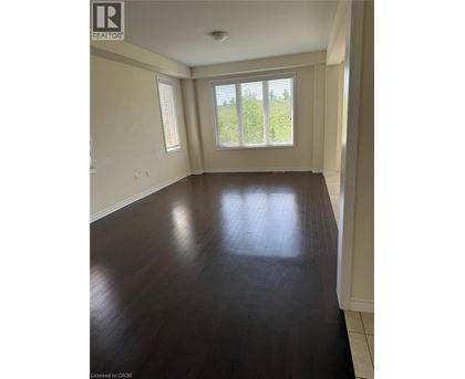 A room with wooden floors and a window overlooking a green area.