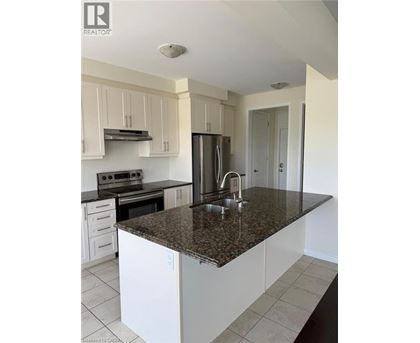 A kitchen with white cabinets and a granite countertop.