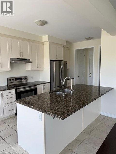 A kitchen with white cabinets and a granite countertop.