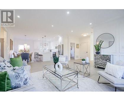 A living room with a glass coffee table and a white sofa.