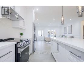 A modern kitchen with white cabinets and a black stove top oven.