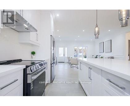 A modern kitchen with white cabinets and a black stove top oven.