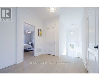 A white bedroom with a bed and a chandelier.