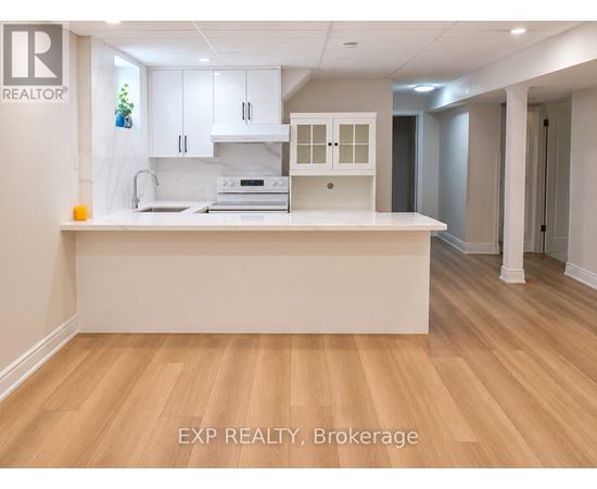 A kitchen with white cabinets and a wooden floor.