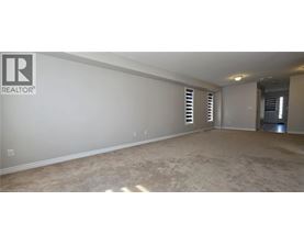 A spacious room with a carpeted floor and a Realtor logo on the wall.