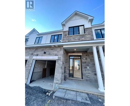 A house with a stone facade and a garage door is for sale.