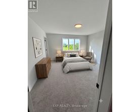 A bedroom with a large bed and a window overlooking a green area.
