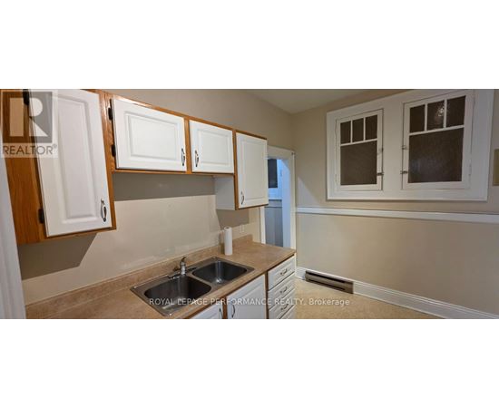 A kitchen with white cabinets and a sink.