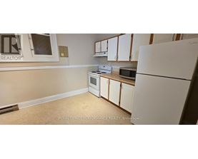 A kitchen with white appliances and cabinets.