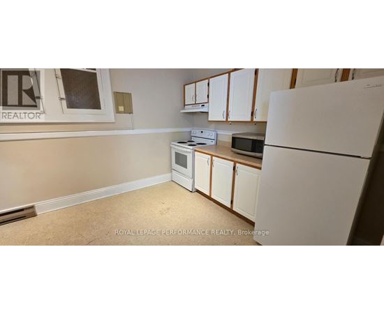 A kitchen with white appliances and cabinets.