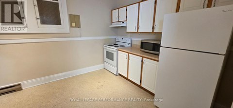 A kitchen with white appliances and cabinets.