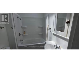 A white bathroom with a tub, toilet and sink.