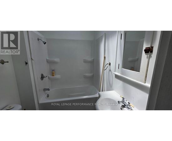 A white bathroom with a tub, toilet and sink.
