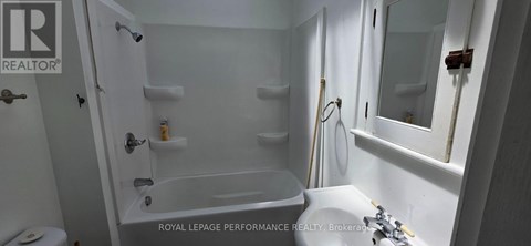 A white bathroom with a tub, toilet and sink.