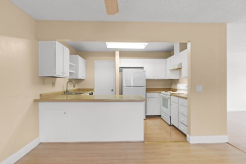 A kitchen with white cabinets and appliances.