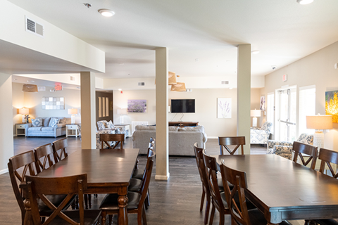 A large dining room with a long table and chairs.