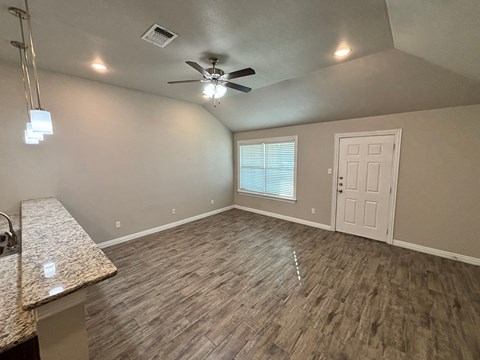 A room with a ceiling fan and a window with blinds.