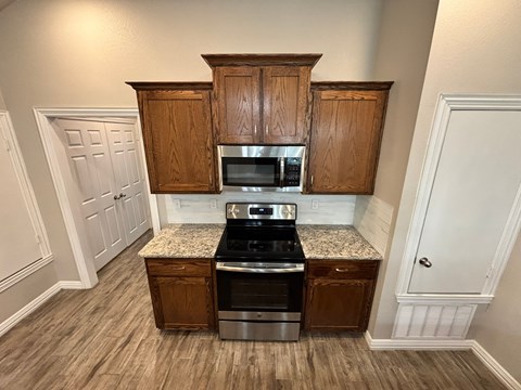 A kitchen with wooden cabinets and a granite countertop.