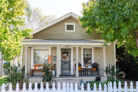 A house with a front porch and a white picket fence.
