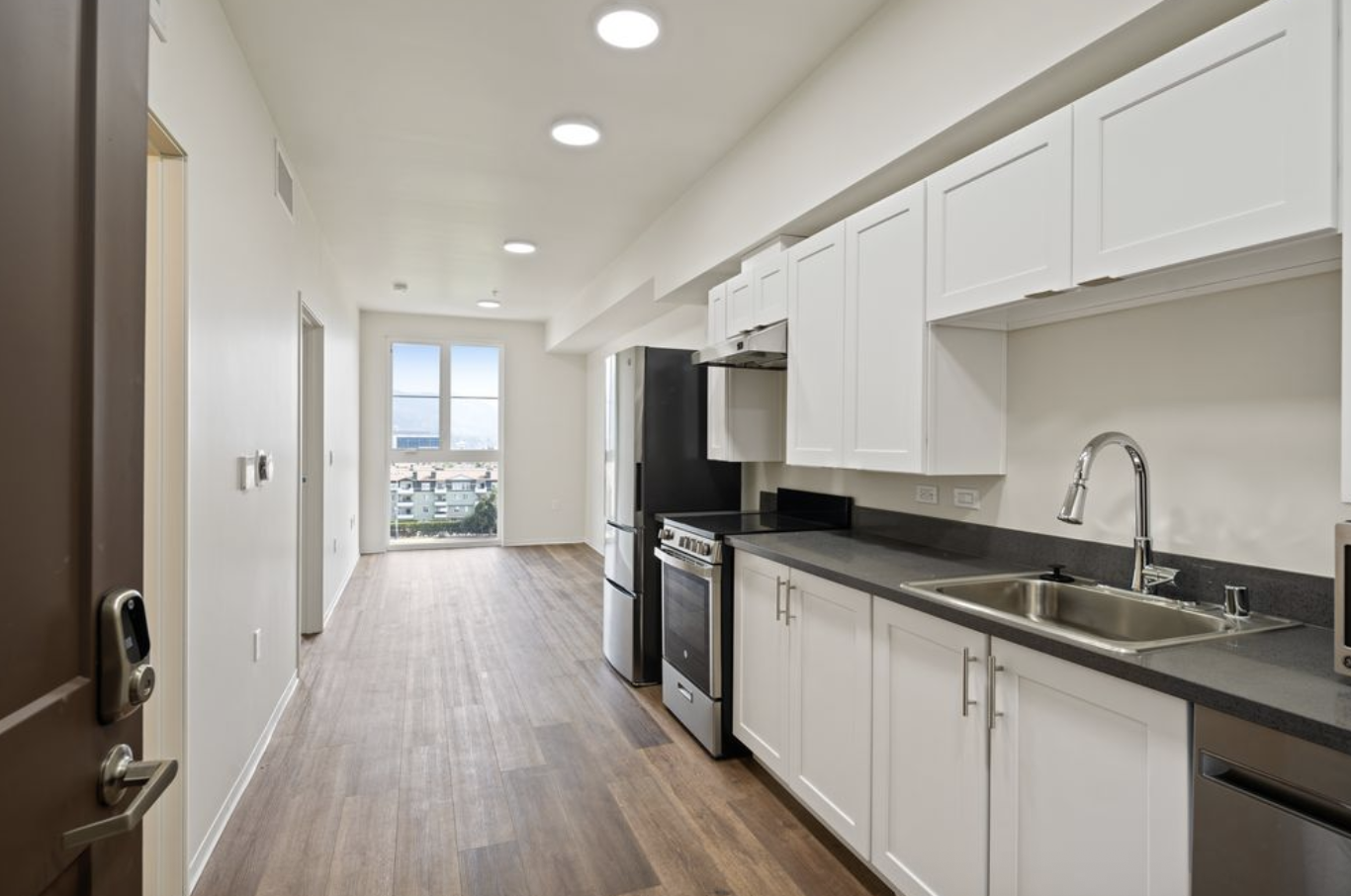 A modern kitchen with white cabinets and stainless steel appliances.