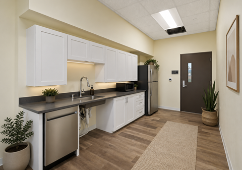 A kitchen with white cabinets and a black countertop.