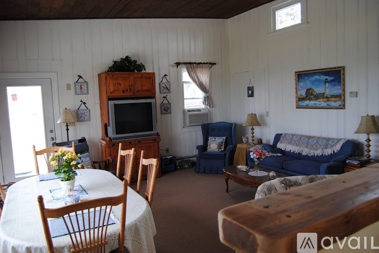A living room with a blue couch and a wooden entertainment center.