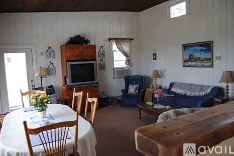 A living room with a blue couch and a wooden entertainment center.