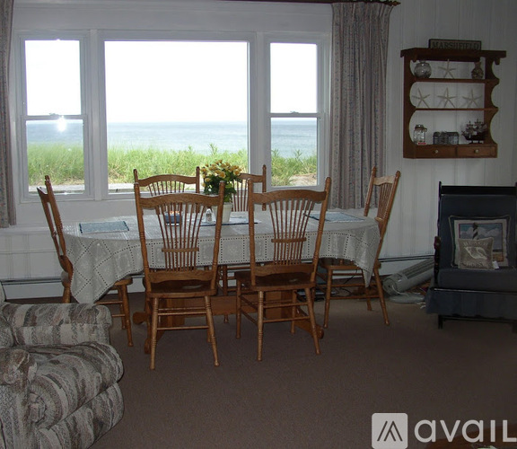 A dining room with a table and chairs.