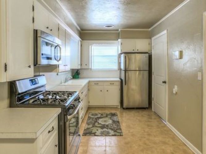 A kitchen with white cabinets and appliances.