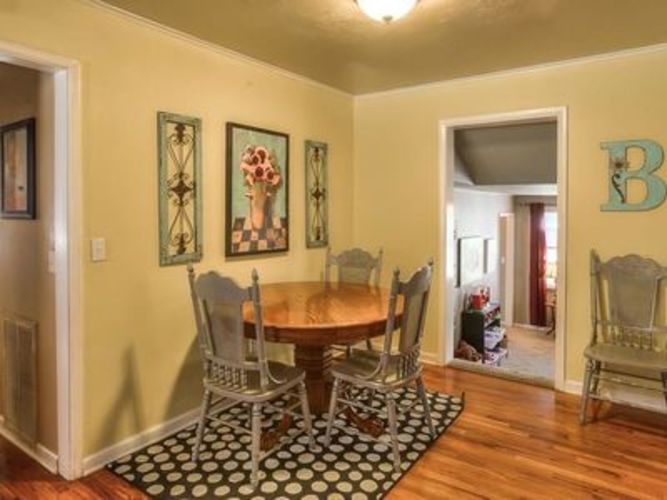 A dining room with a wooden table and chairs.