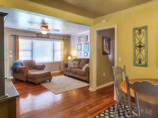 A living room with a brown sofa and a wooden floor.