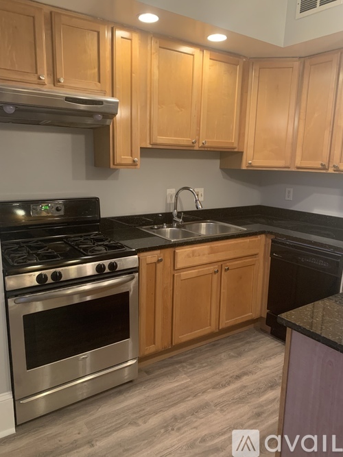 A kitchen with wooden cabinets and a stainless steel oven.