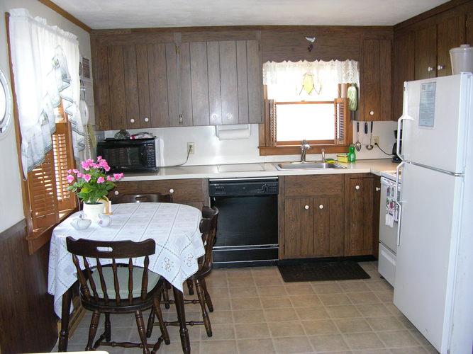 A kitchen with a table and chairs.