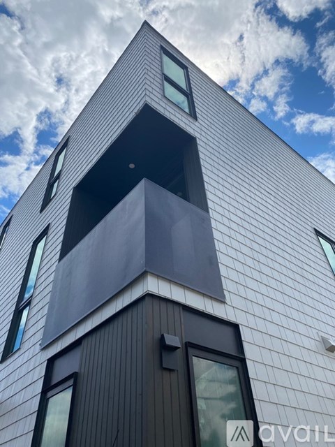 A modern building with a white facade and a balcony.