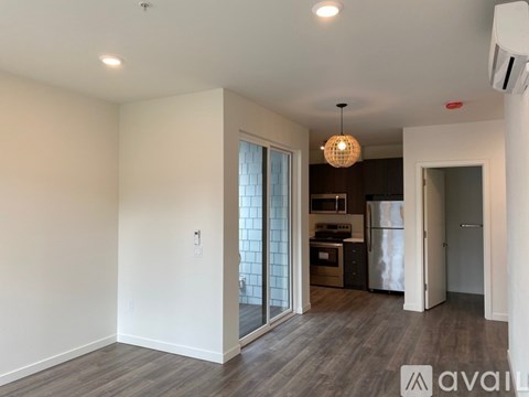 A kitchen area with a refrigerator, oven, and a dining table with chairs.