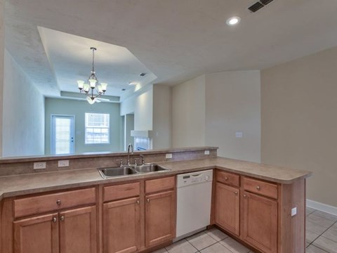 A kitchen with wooden cabinets and a dishwasher.