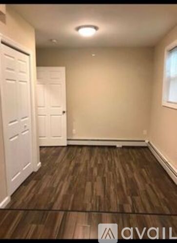 A room with wooden flooring and white doors.