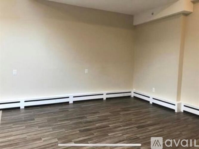 A room with wooden flooring and white trim.
