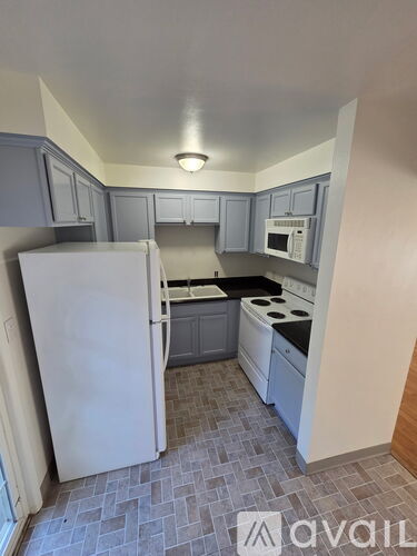 A kitchen with a white refrigerator and a microwave above the stove.