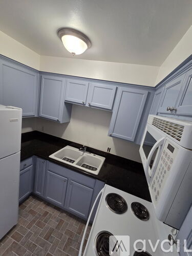 A kitchen with a white fridge, white oven, and white microwave.