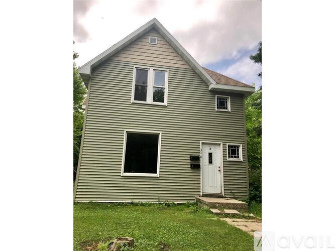 A house with a grey siding and a white door.