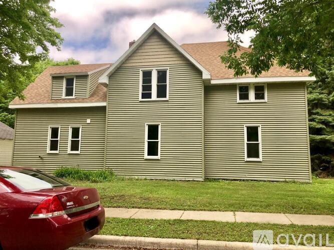A house with a red car parked in front.