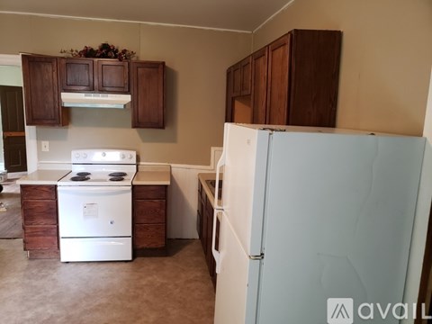 A kitchen with a white stove and a white refrigerator.