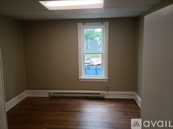 A room with a window and a wooden floor.