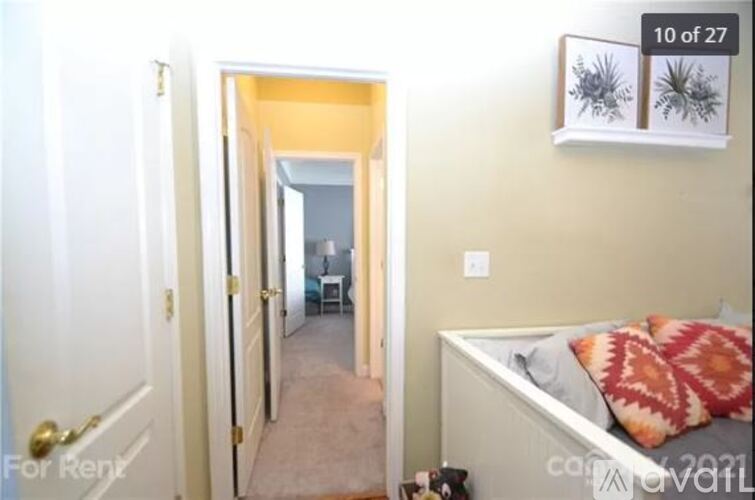 A bedroom with a bed and a picture of a plant on the wall.