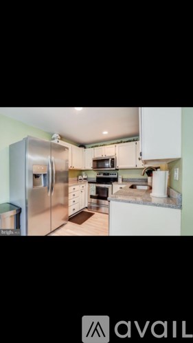 A kitchen with white cabinets and appliances.