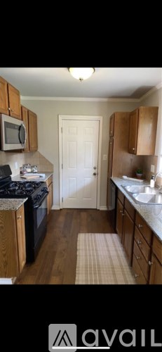 A kitchen with wooden cabinets and a white door in the background.