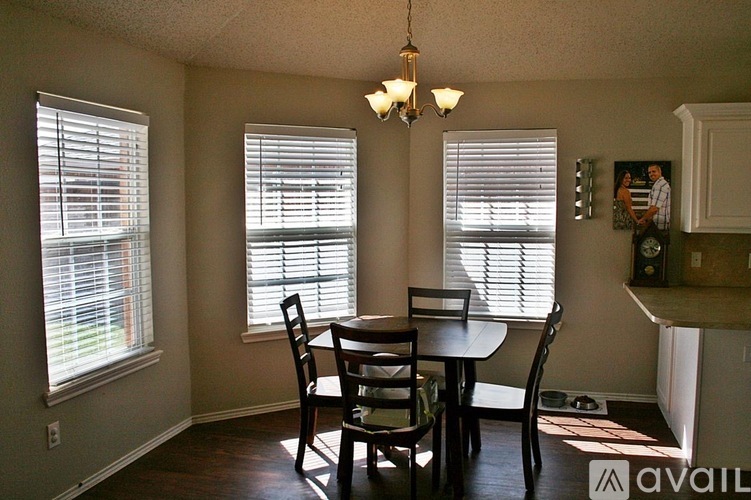 A dining room with a table and chairs.