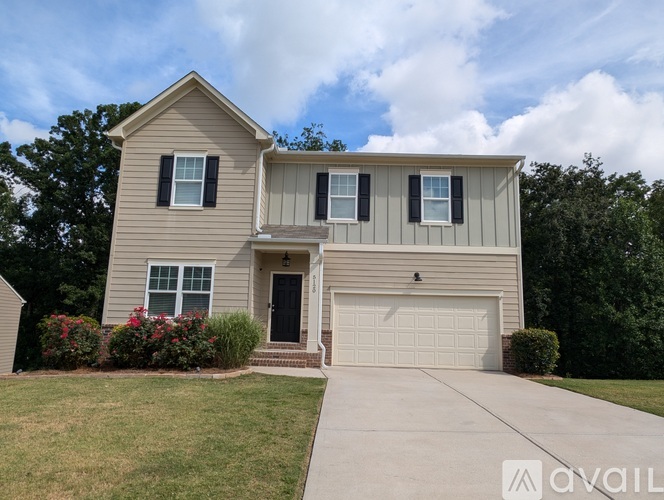 A two-story house with a garage and a front porch.
